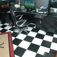 Cave aménagée en salle gaming avec sol en damier noir et blanc en dalles clipsables SWISSTRAX