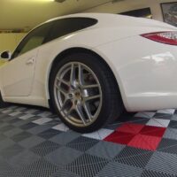 Checkerboard effect floor tiles in a garage with a car