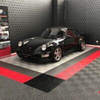 a porsche in the showroom of a detailing center with swisstrax tiles flooring