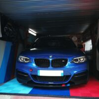 BMW bleue dans un garage aménagé avec des dalles de sol clipsables