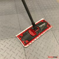 swipping swisstrax modular flooring with a flat mop