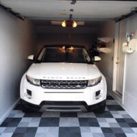 white Range rover parked in a garage with floor tiles