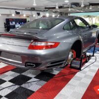 Pose d’un pont central dans un atelier detailing équipé de dalles Swisstrax