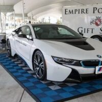 BMW électrique sur tapis en dalles clipsables pour zone de présentation