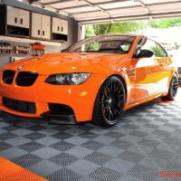 BMW orange dans un garage équipé avec des dalles clipsables plastique